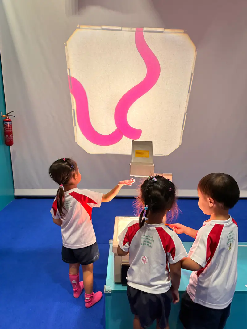Three Shaws children working out how an interactive light wall responds to their hands
