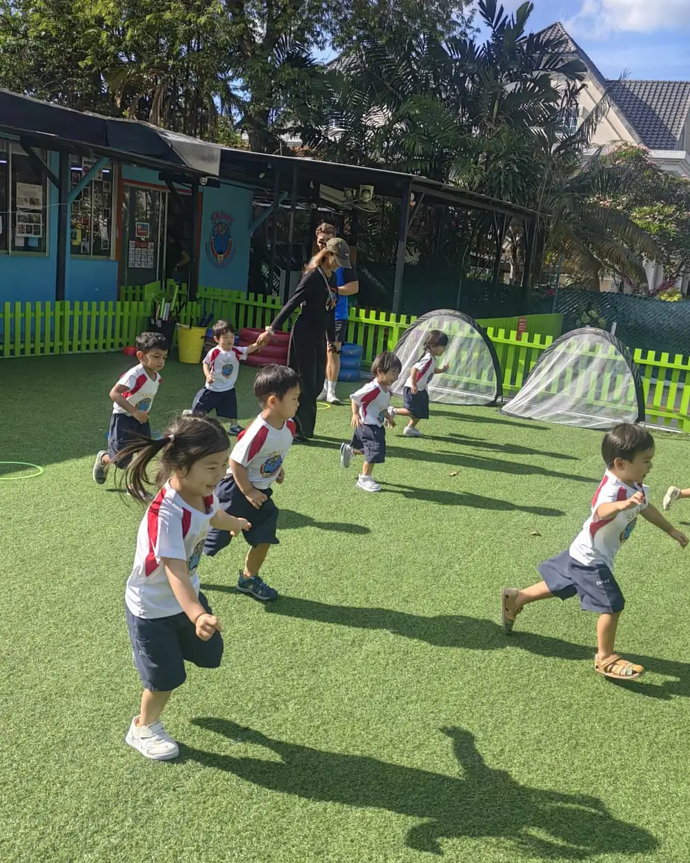 A class of Shaws children sprinting across the field towards goals during Shaws Little League training