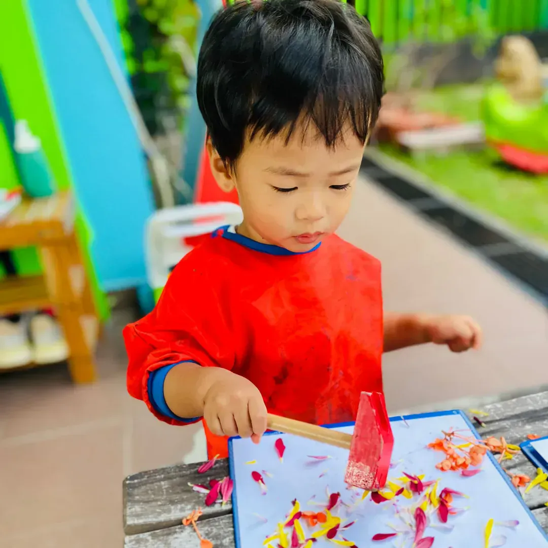 A teacher supporting a child during a hands-on activity